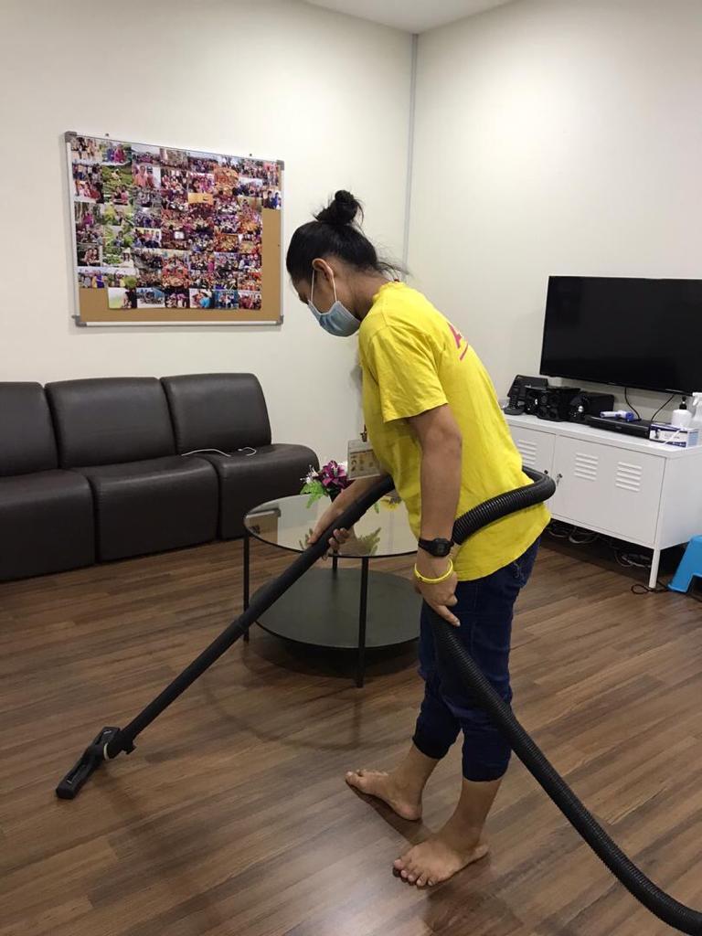 Angel Cleaning team member vacuuming a living room